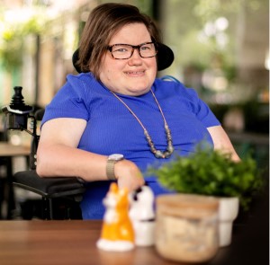 An image of Liz smiling in a cafe