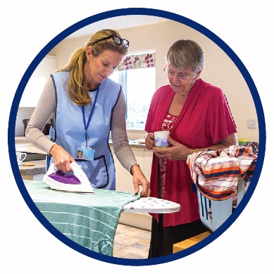 A woman helping another woman do the ironing