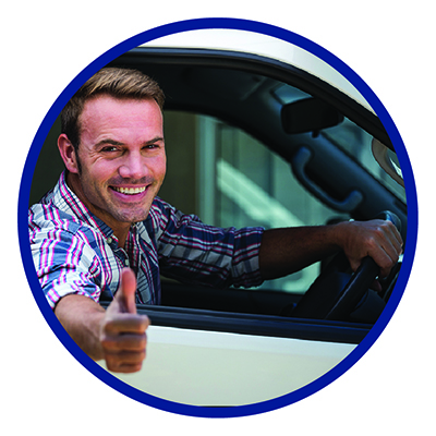 A man driving a car, smiling with thumbs up