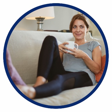 A woman sitting on a sofa with a cup of tea.