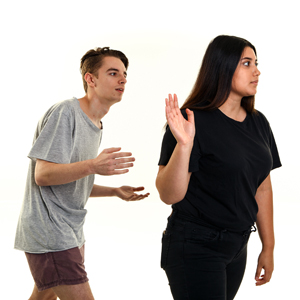 A man trying to talk to a woman but the woman has turned away and is not listening.