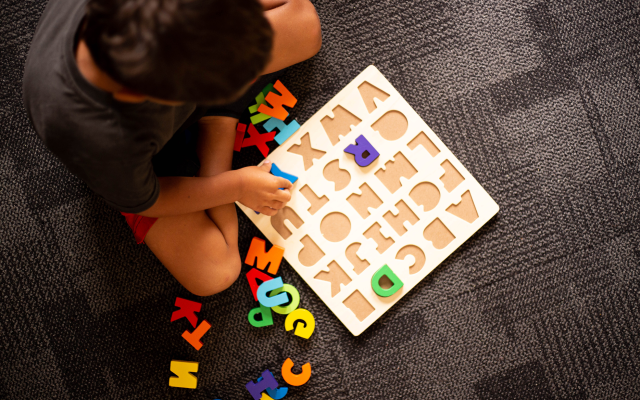 image of a boy sitting down playing a board game